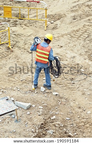 VICTORIA, HONG KONG - JAN 8: worker with electric cable and helmet on Jan 8, 2010 in Victoria, Hong Kong. Helmet and safety west is a must in Hong Kong for workers  and checked by police.