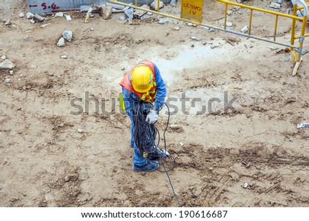 VICTORIA, HONG KONG - JAN 8: worker with electric cable and helmet on Jan 8, 2010 in Victoria, Hong Kong. Helmet and safety west is a must in Hong Kong regulations for workers at construction sites.