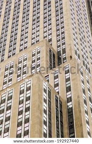 NEW YORK, USA - JULY 11, 2010: Facade of Empire State Building in the afternoon with iron statue of Man on the roof in New York, USA. British Artist Antony Gormley installed the iron man.