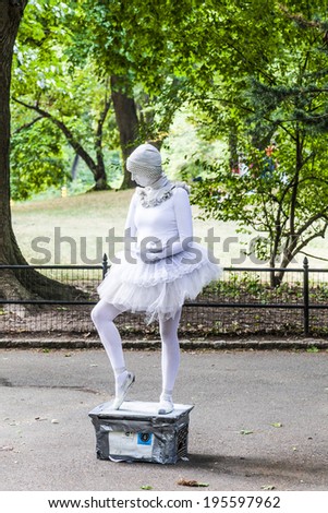NEW YORK, USA -JULY 11, 2010: Woman dressed as a ballet dancer in white showing pantomines to collect money for Amnesty International in the collecting box  in New York, USA.