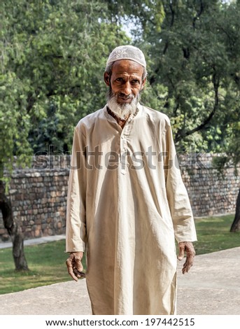 DELHI, INDIA - NOVEMBER 11, 2011: A muslim tribal man wearing traditional taqiyah (muslim cap) and galabia poses in the garden of Hayumans tomb in Delhi, India.