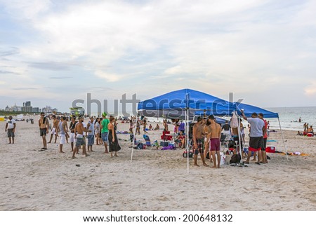 MIAMI, USA - JULY 28, 2013: people enjoy the beach in the evening in Miami, USA. South beach is famous for its wooden lifeguard towers which are designed in Art deco style.