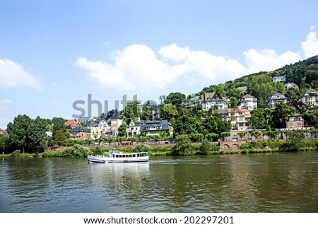 HEIDELBERG, GERMANY - JULY 6, 2013: river cruise ship on the Neckar in Heidelberg. River cruises on scenic Neckar River are popular for visitors of Heidelberg.