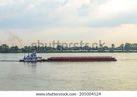 BATON ROUGE, USA - JULY 13, 2013: freight ship on Mississippi river at sunset in Baton Rouge, USA. The Mississippi ranks as the fourth longest and tenth largest river in the world.