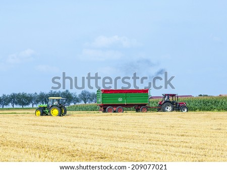 ESCHBORN, GERMANY - JULY 27, 2014: Farmer with tractor at the field in harvest time in Eschborn, Germany. As of 2009, it had a population of 20,789.