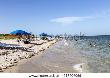 MIAMI, USA - AUG 22, 2014: People relax at the Crandon Park beach in Miami, USA. The park is more than 800 acres in size, and has two miles  of beach on the Atlantic Ocean side.