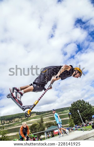 BINGEN, GERMANY - SEP 15, 2013: teen jumps with scooter over a ramp and performs a salto in Bingen, Germany. The first Bingen scooter contest is organised by the city of Bingen and Conrad Thorben.