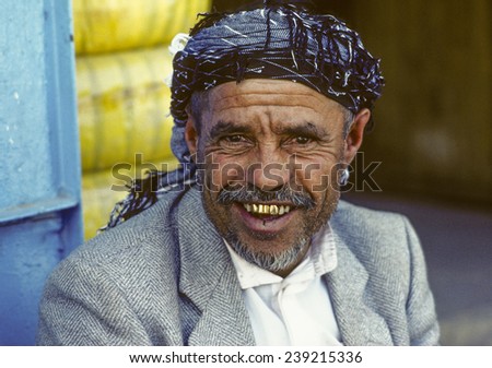 SANAA, YEMEN - JUNE 30, 1991: portrait of old smiling man in Sanaa, Yemen. The man wears gold teeth which are a symbol for wealth and rich people,