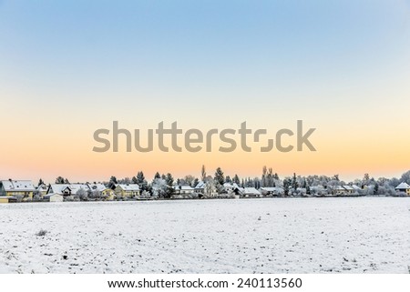 snow covered fields with settlement at the horizon in Munich,Germany