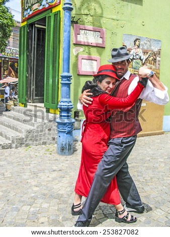 BUENOS AIRES, ARGENTINA - JAN 26, 2015: tango dancer pose for tourists in Caminito Street, Buenos Aires, Argentina. Caminito is a traditional alley, located in La Boca.