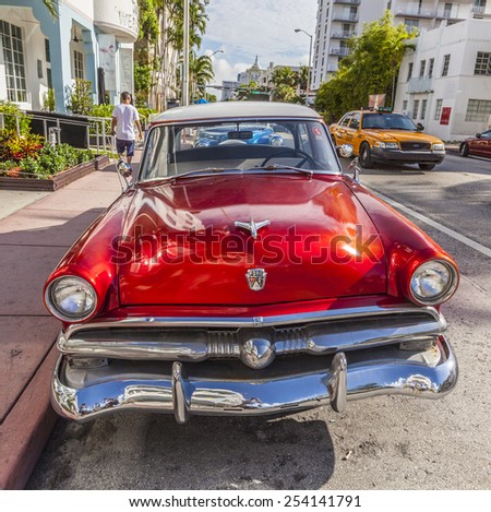 MIAMI, USA - AUG 5, 2013: The Art Deco district in Miami and a classic Ford car on Ocean Drive, South Beach, Miami, USA. Classic cars are allowed to park at yellow line.