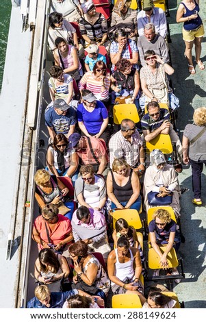 PARIS, FRANCE - JUNE 13, 2015: people enjoy the boat trip on River Seine in Paris, France.  Some 3.5 million passengers per year discover  Paris by a Seine boat trip.