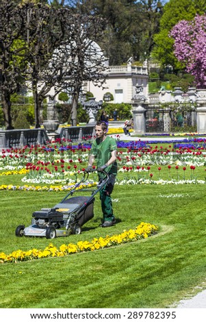 SALZBURG, AUSTRIA - APR 21, 2015: Lawn mover machine prepares the green in Mirabelle Gardens in Salzburg, Austria. The gardener is employed by the city of Salzburg.