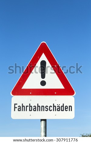 street sign - Street Damage -  with warning icon under blue sky