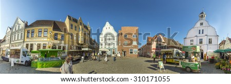 WOLGAST, GERMANY - AUG 13, 2015: people at market place with old town hall in Wolgast, germany. Most houses of the Old Town therefore date back to the 18th and 19th centuries.