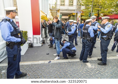 FRANKFURT, GERMANY - OCT 3, 2015: Demonstrant is being checked by police during the 25th anniversary of German Unity in Frankfurt, Germany.