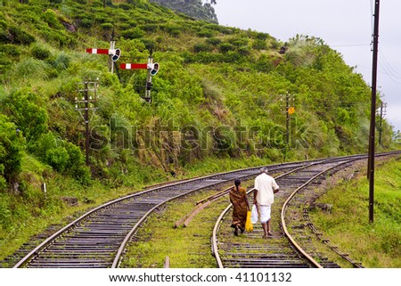 people are passing the railroad track in the high mountains of Sri Lanka