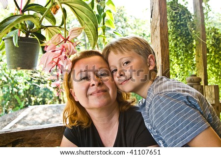 son gently touches his mother face to face and both are happy and smiling