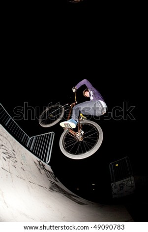 young boy jumpy with his scooter by night with stroboscope