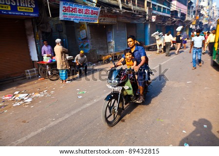 DELHI, INDIA - NOV 9: Unidentified motorbike rider with unidentified child on early morning on November 09,2011 in Delhi, India. Motor bike is the favorite  transportation in the narrow streets of old Delhi.