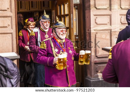 FRANKFURT, GERMANY - MARCH 5: man in carnival uniform gets some beer during the parade on March 5, 2011 in Frankfurt, Germany. Carneval people conquest the town hall and get the key for one day.
