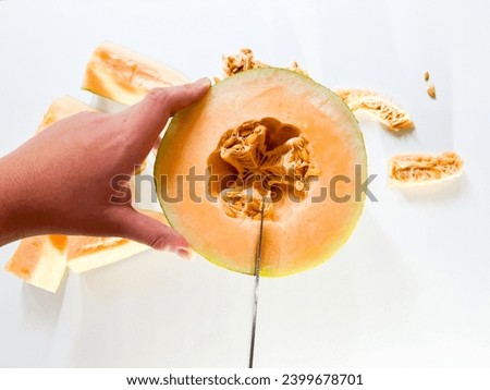Similar – Image, Stock Photo Halved watermelon with golden forks and flowers at grey concrete kitchen table with champagne glasses