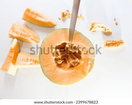 Similar – Image, Stock Photo Halved watermelon with golden forks and flowers at grey concrete kitchen table with champagne glasses