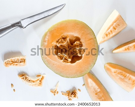 Similar – Image, Stock Photo Halved watermelon with golden forks and flowers at grey concrete kitchen table with champagne glasses