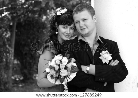 Love story of a nice young wedding couple. Portrait of a beautiful young bride smiling on her wedding day with her handsome groom. An excited bride and groom embrace each other on their wedding day
