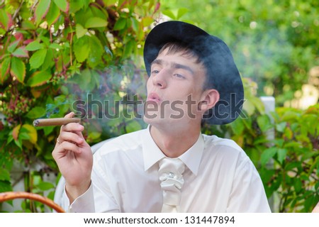 Gangster look. Handsome man with hat and cigar. Happy young groom outside on their wedding day. Wedding couple - new family! wedding dress. Bridal wedding bouquet of flowers