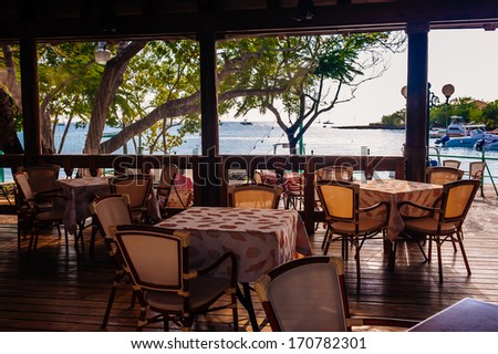 Summer empty open air restaurant near sea at sunset in Dominican Republic. Vintage black and white photography