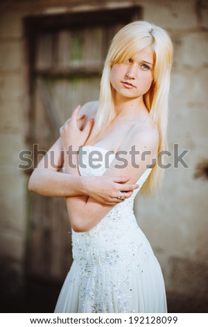 Beauty Girl Outdoors enjoying nature. Beautiful Teenage Model girl in white dress on the Spring Field, Sun Light. gorgeous bride enjoying walking in spring forest. Free Happy Woman. warm colors