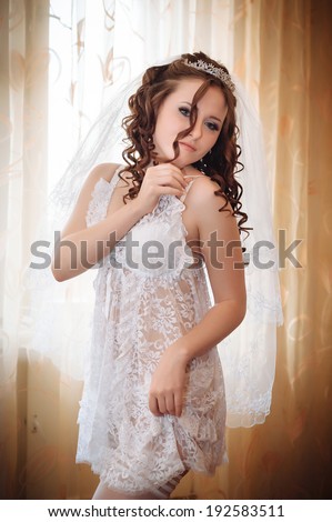 Young and sexy woman in white lingerie. bride with hairstyle and bright makeup. Happy sexy girl waiting for groom. lady in bridal dress have final preparation for wedding. Body in sexy bridal lingerie