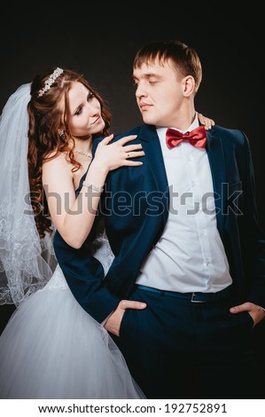 newly-married couple on the isolated black background. Affectionate bride and groom with head to head. Loving bride and groom