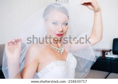 Portrait of beautiful woman in white dress. adorable bride is getting ready in the morning. Adorable young bride is getting ready in the morning at home.