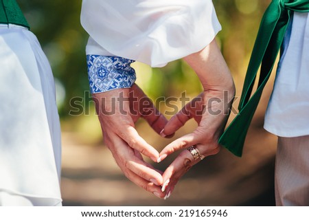 Hands of bride and groom. Ukraine. Happy ukrainian wedding (bridal) couple in the ukrainian style. Beautiful bride and groom in the ukrainian style are standing with bouquet. Female and male models.