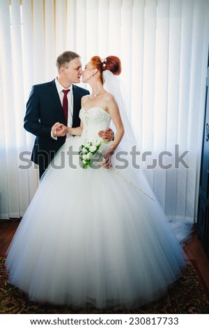 Newlyweds embraces. Beautiful newly married couple kissing at registry office.