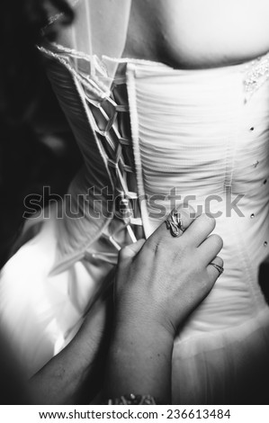 Bride getting ready. Bride dressing gown. bride is getting ready in the morning. Brides maid helps bride dress in wedding dress for wedding day