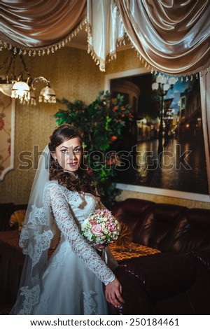 Gorgeous bride blonde in wedding dress in luxury interior posing at home and waiting for groom. Romantic rich beautiful brunette bride in a luxurious wedding dress in elegant expensive interior