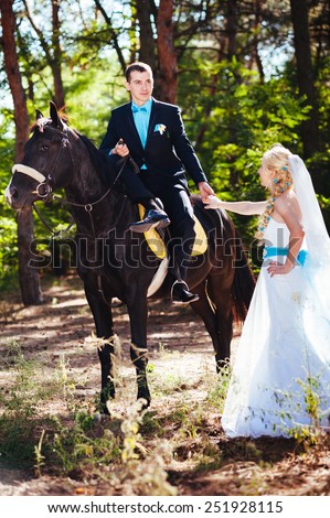 Bride and groom with horse. Portrait of a fashion bride and groom with brown horse.