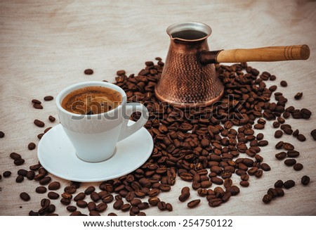 Coffee turk and cup of coffee on burlap background. coffee beans isolated on white background. roasted coffee beans