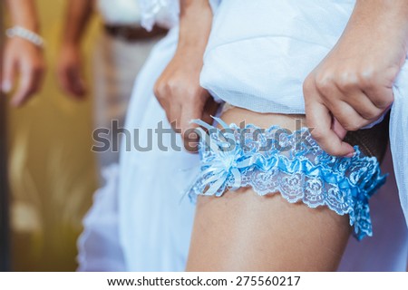 bride is putting on a wedding garter.