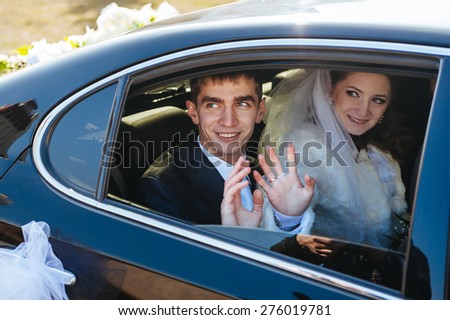 Bride and groom kissing in limousine on wedding-day