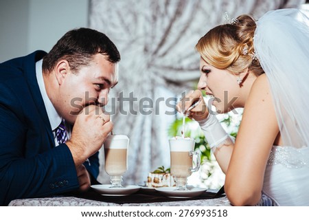 Hands of bride and groom. Cappuccino or latte coffee with heart shape. bride and groom drink a cup of Coffee latte on the date. Happy bride and groom drink a cup of Coffee latte with heart design.