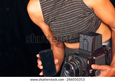 Black female photographer comparing new and old technology