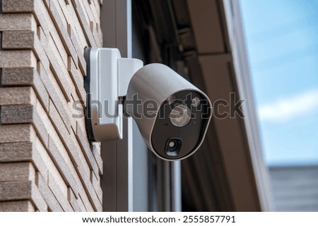 Image, Stock Photo Surveillance camera on a light pole behind a wall with barbed wire