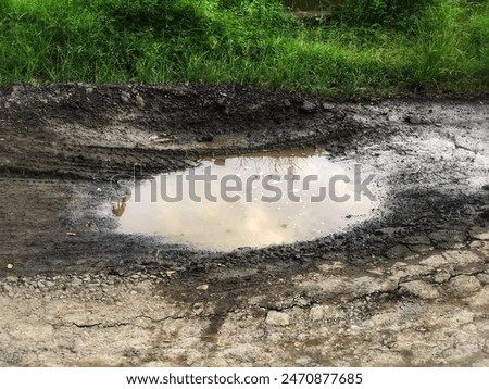 Similar – Foto Bild Pfützen auf einer Landstraße nach Regenfällen. Schwarz und weiß düstere Landschaft Szene