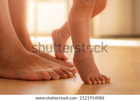 Similar – Image, Stock Photo Toddler learning to walk using push toy; child reaching to play with toy on front of walker