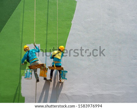 Foto Bild Arbeiter baut Mauer mit roten Blöcken und Mörtel