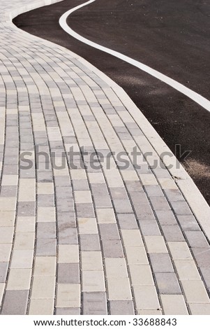 Sidewalk and street curve detail, stone patterns leading the way